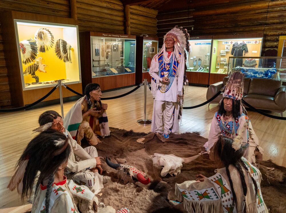 Artifacts and mannequins covered with traditional Indigenous clothing displayed at Buffalo Nations Museum in Banff National Park.